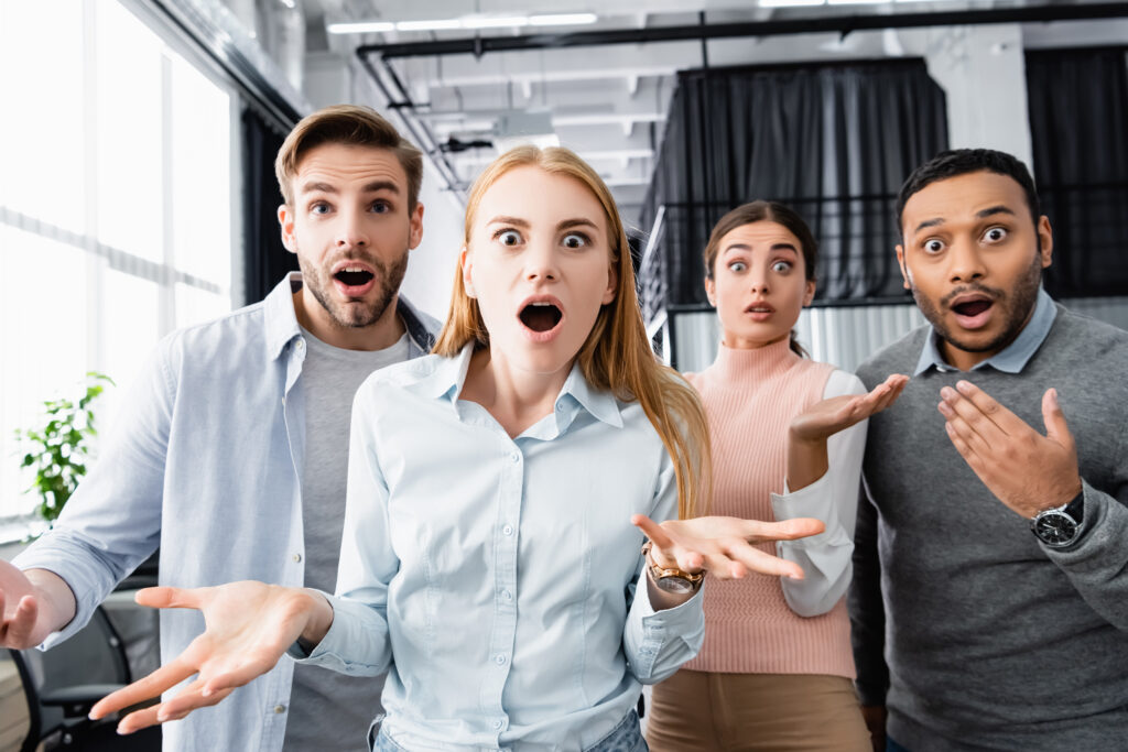 Shocked multiculturral businesspeople looking at camera in office