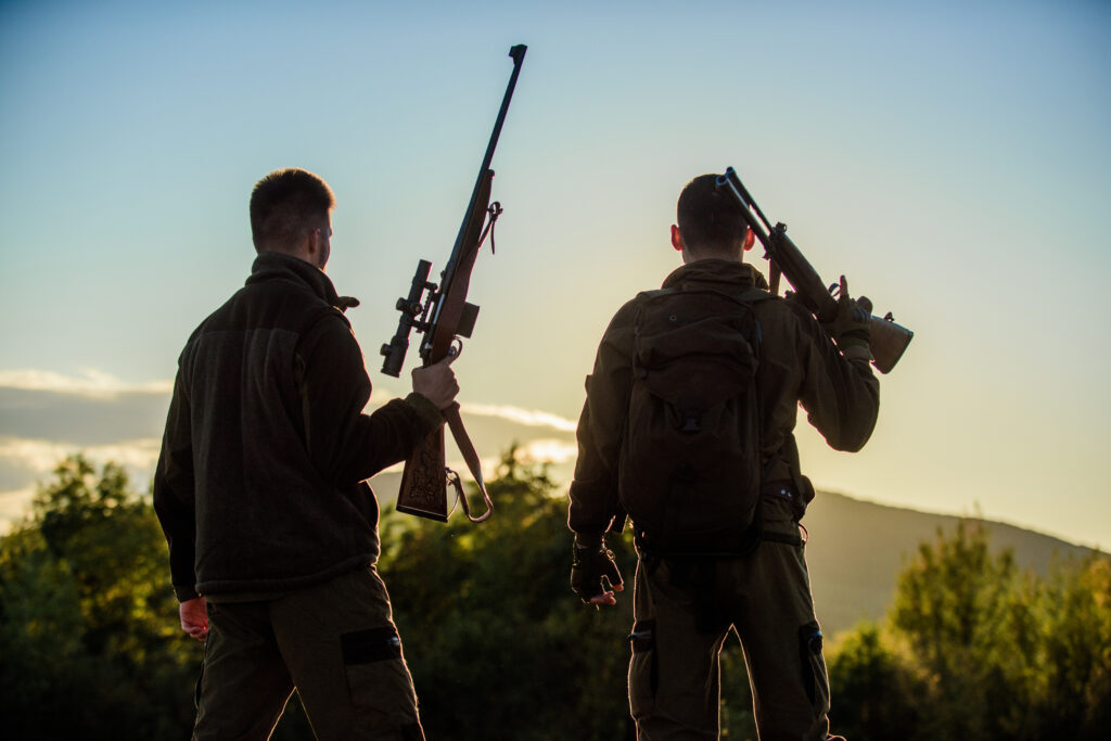 Hunters rifles nature environment. That was great day. Finish hunting season. Enjoy sunset in mountains. Hunters friends enjoy leisure. Hunters friends gamekeepers with guns silhouette sky background.